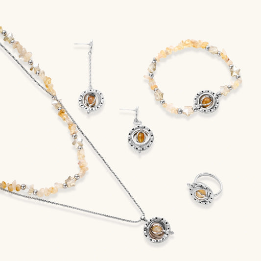 Complete jewelry set featuring citrine stone chips, silver beads, and cosmic circle pendants on cream background.