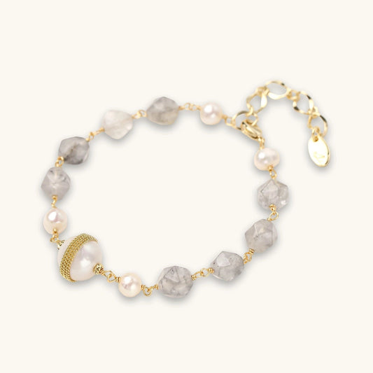 Havora bracelet featuring grey faceted gemstone beads, freshwater pearls, and a gold-coiled pearl on a gold chain.