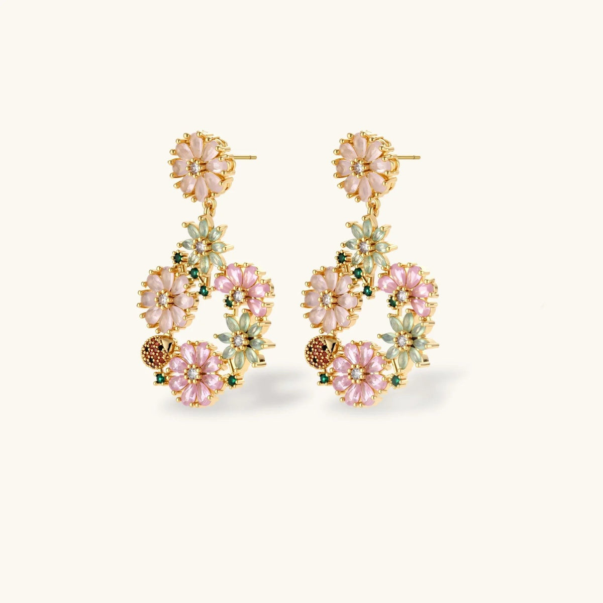 Havora gold-tone drop earrings featuring pastel pink and sage green floral motifs with crystal and ladybird accents.