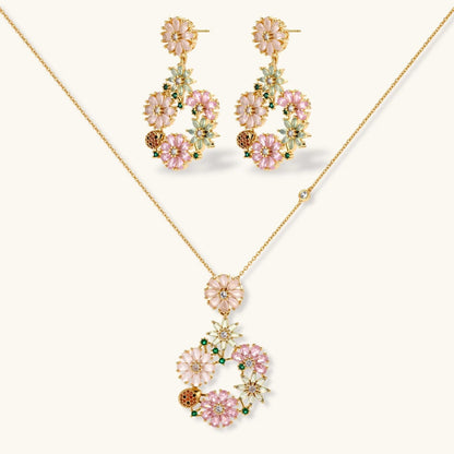 Havora floral jewellery set with gold-tone necklace and drop earrings featuring pink, green petals and ladybirds.