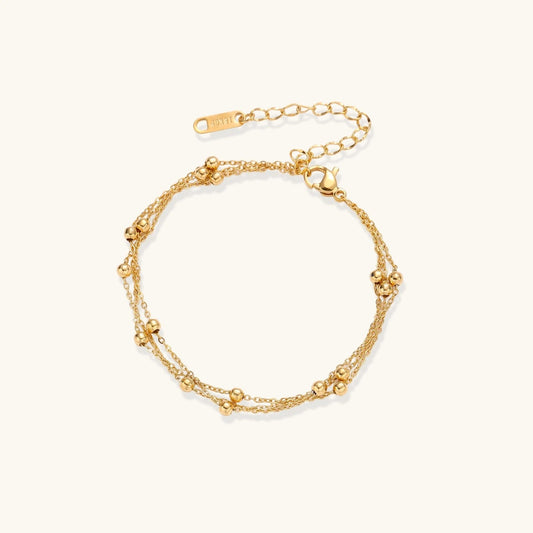 Havora Golden Orbit bracelet featuring three layered 18K gold plated stainless steel chains with polished bead accents.